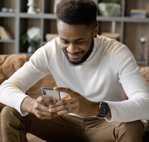 man seated, looking at a mobile device